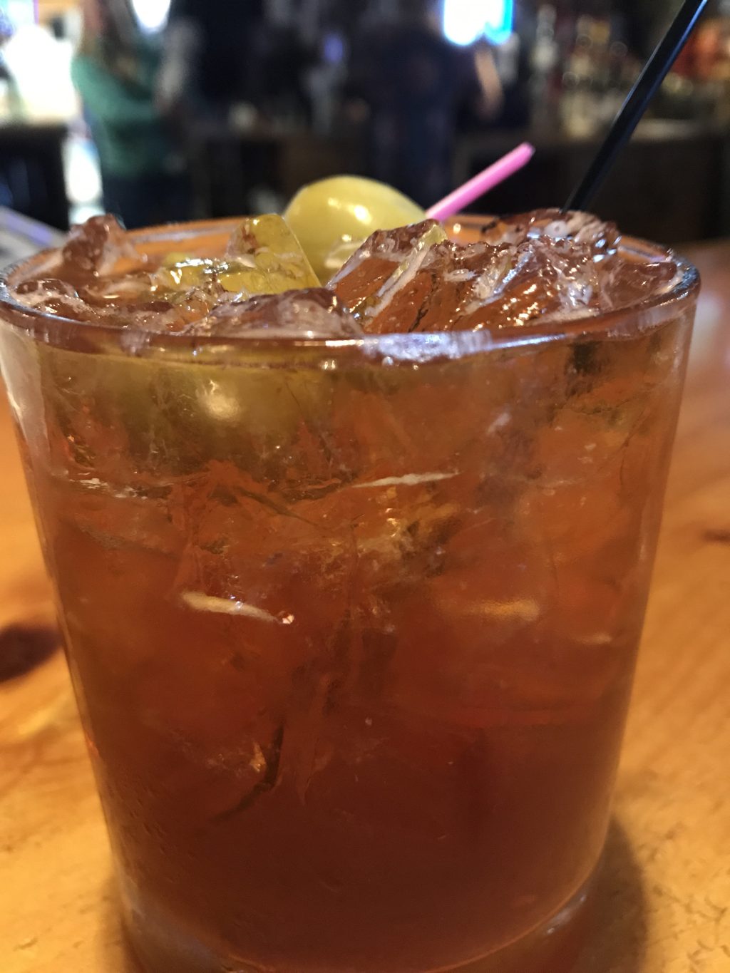A super close up of a brandy Old Fashioned in a glass.