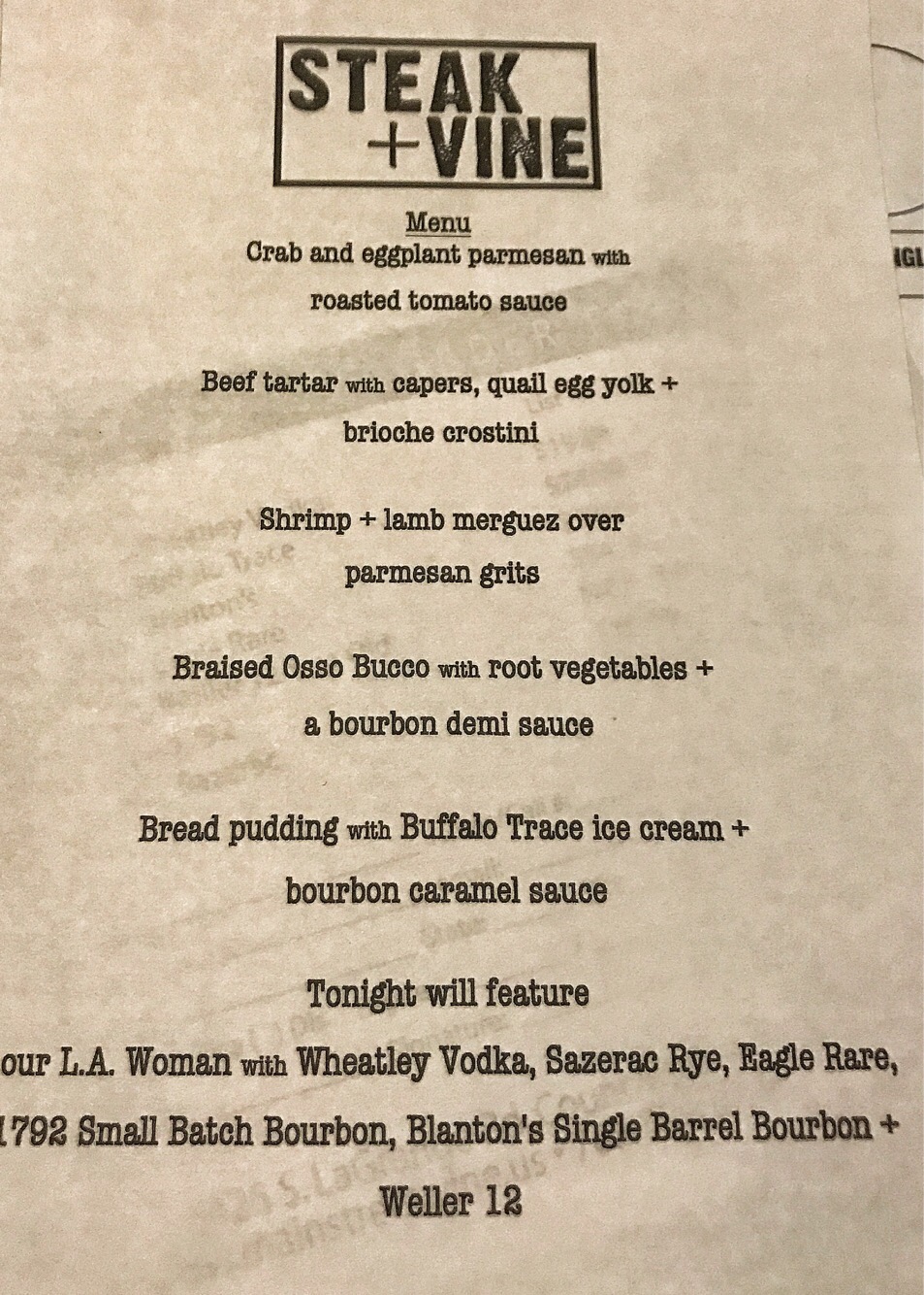 The tasting menu for steak and vine. The different courses are listed in descending order including crab and eggplant parmesan, beef tartare, shrimp and lamb merguez over grits, braised osso bucco, bread pudding, and a series of tasting whiskeys. 