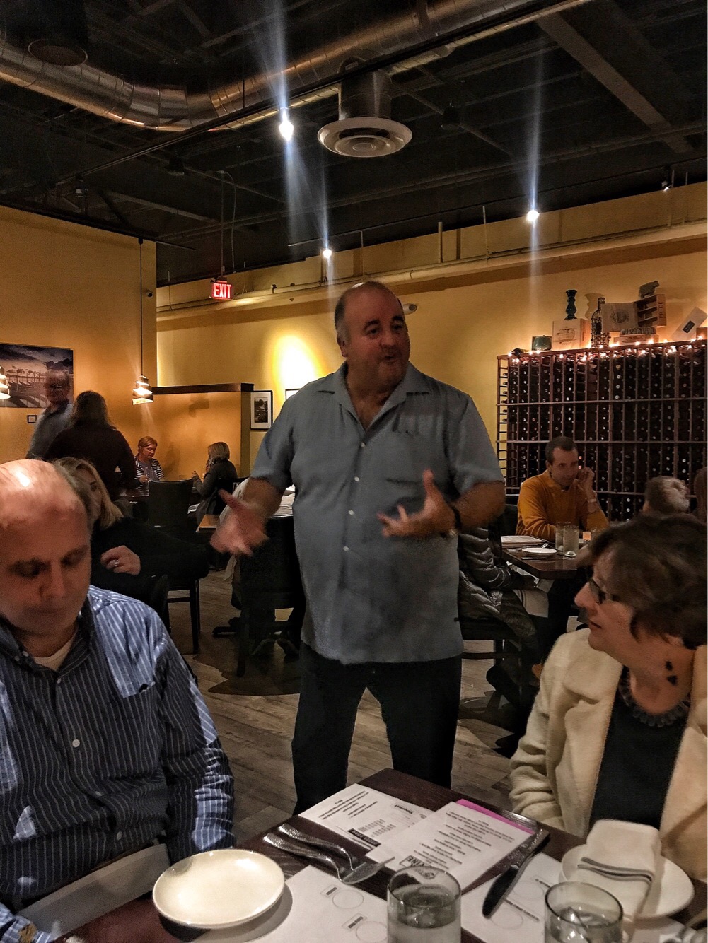 Nick, the owner of Steak and Vine standing in the middle of the dining room surrounded my full tables of diners.