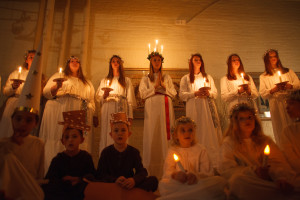Children dressed in white robes and holding candles.