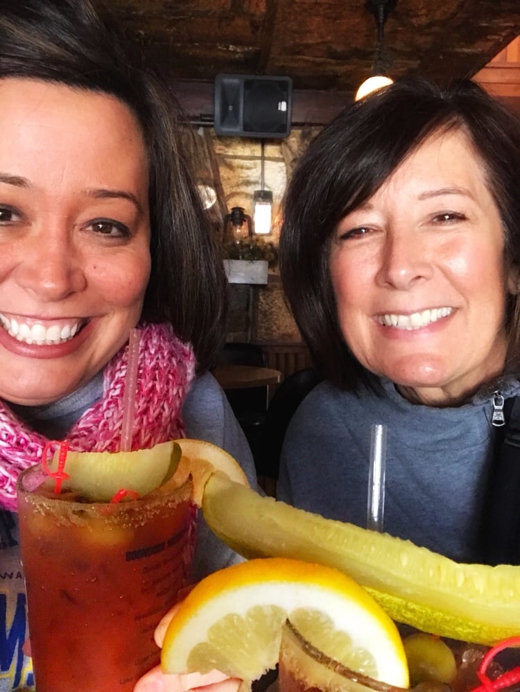 My mom and me holding Bloody Marys with lemon wedges and pickles on top.