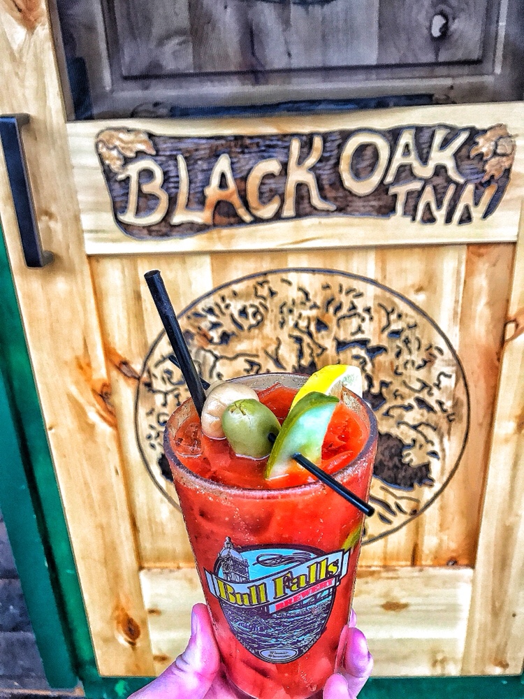 A sign for Black Oak Inn behind a Bloody Mary.