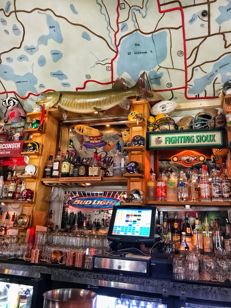 Sports and fishing memorabilia surrounding the cash register behind the bar at Sayner's Pub.