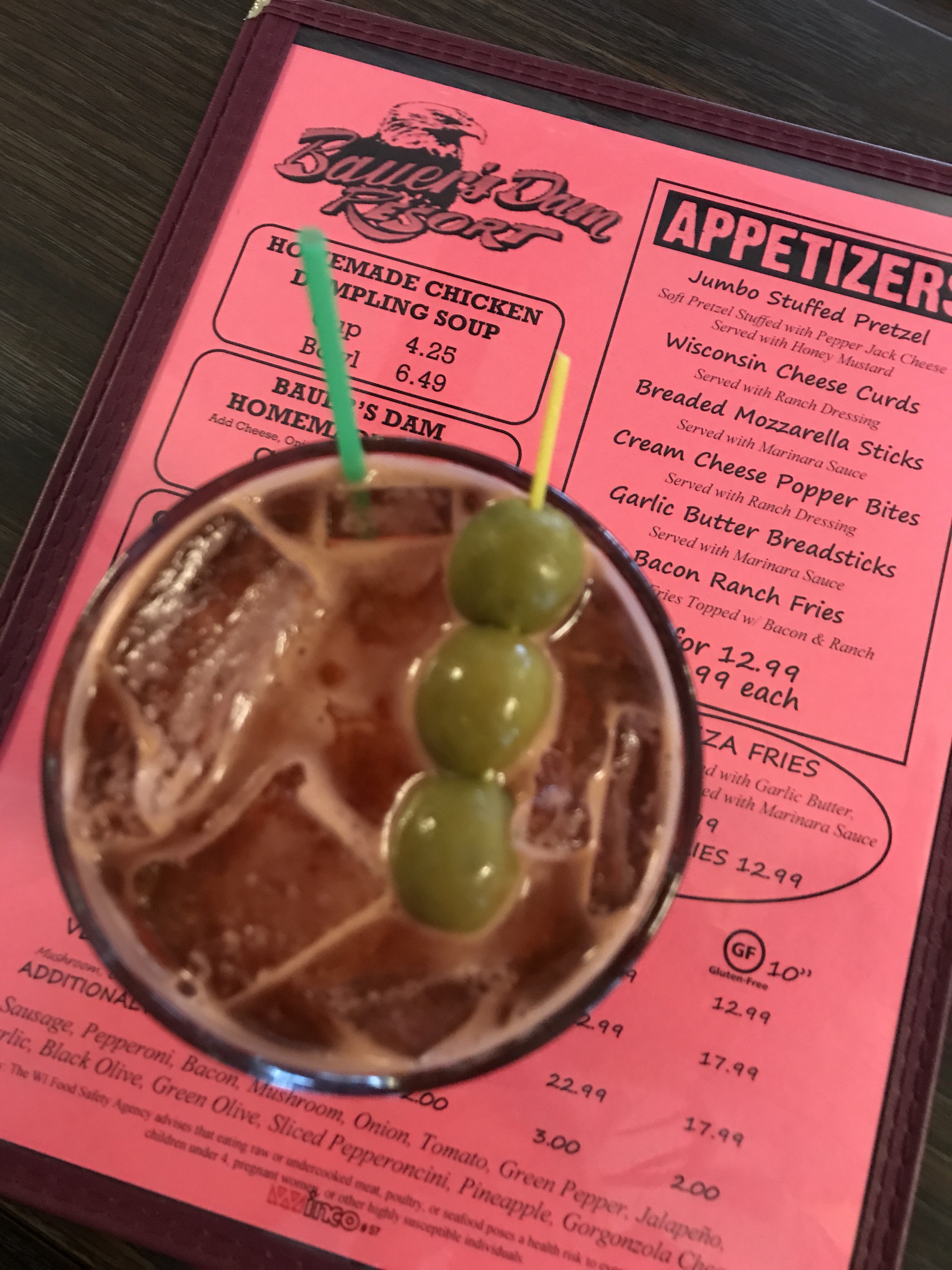 A Bloody Mary seen from above on a pink bar menu.