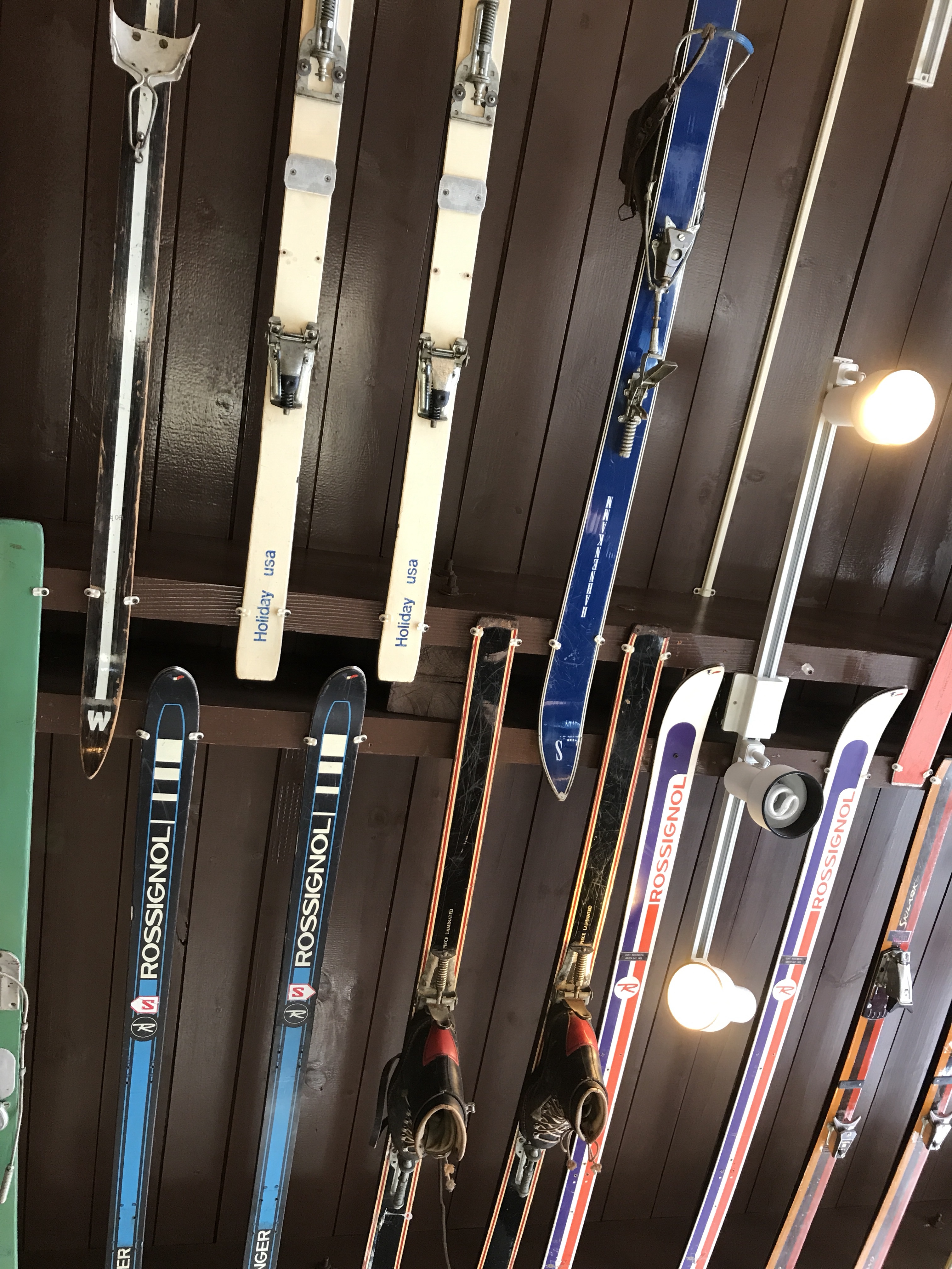 Skis on racks on a wooden wall.