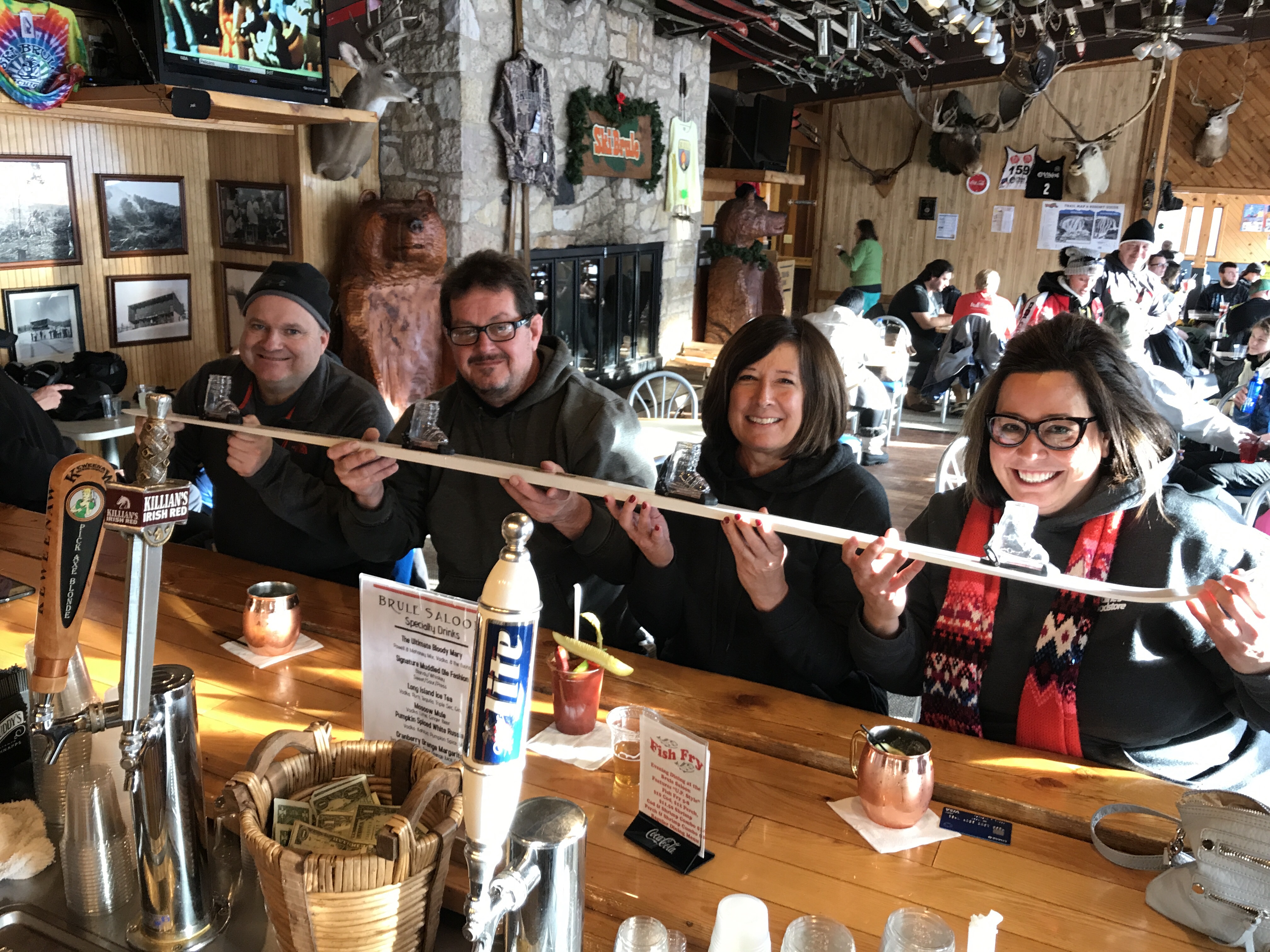 Me and my mom and two others sharing 4 shots shaped like ski boots on a big ski.