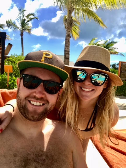 Adam and BitesByBritt on a beach.