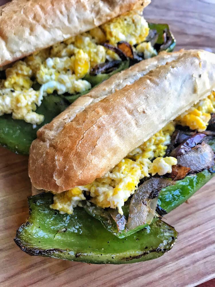 Two pepper and egg sandwiches on hoagie rolls.