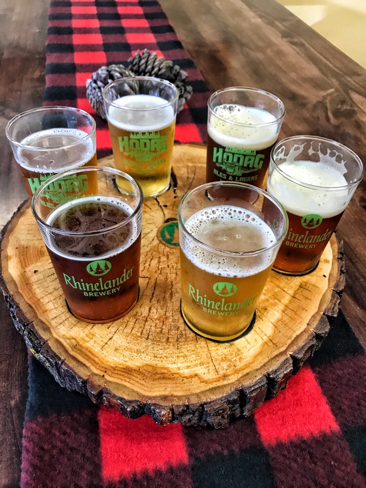 A selection of different beers in a circular wooden platter that looks like a tree ring.