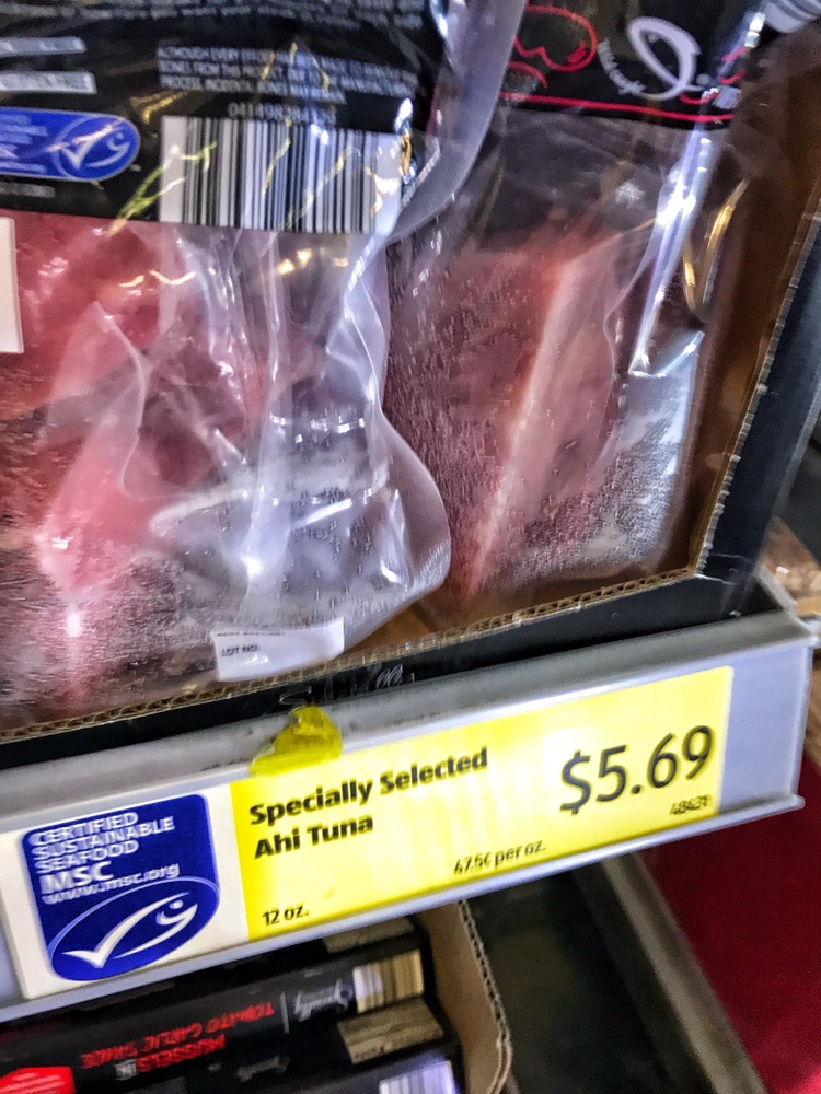 Packages of frozen ahi tuna on a supermarket shelf.