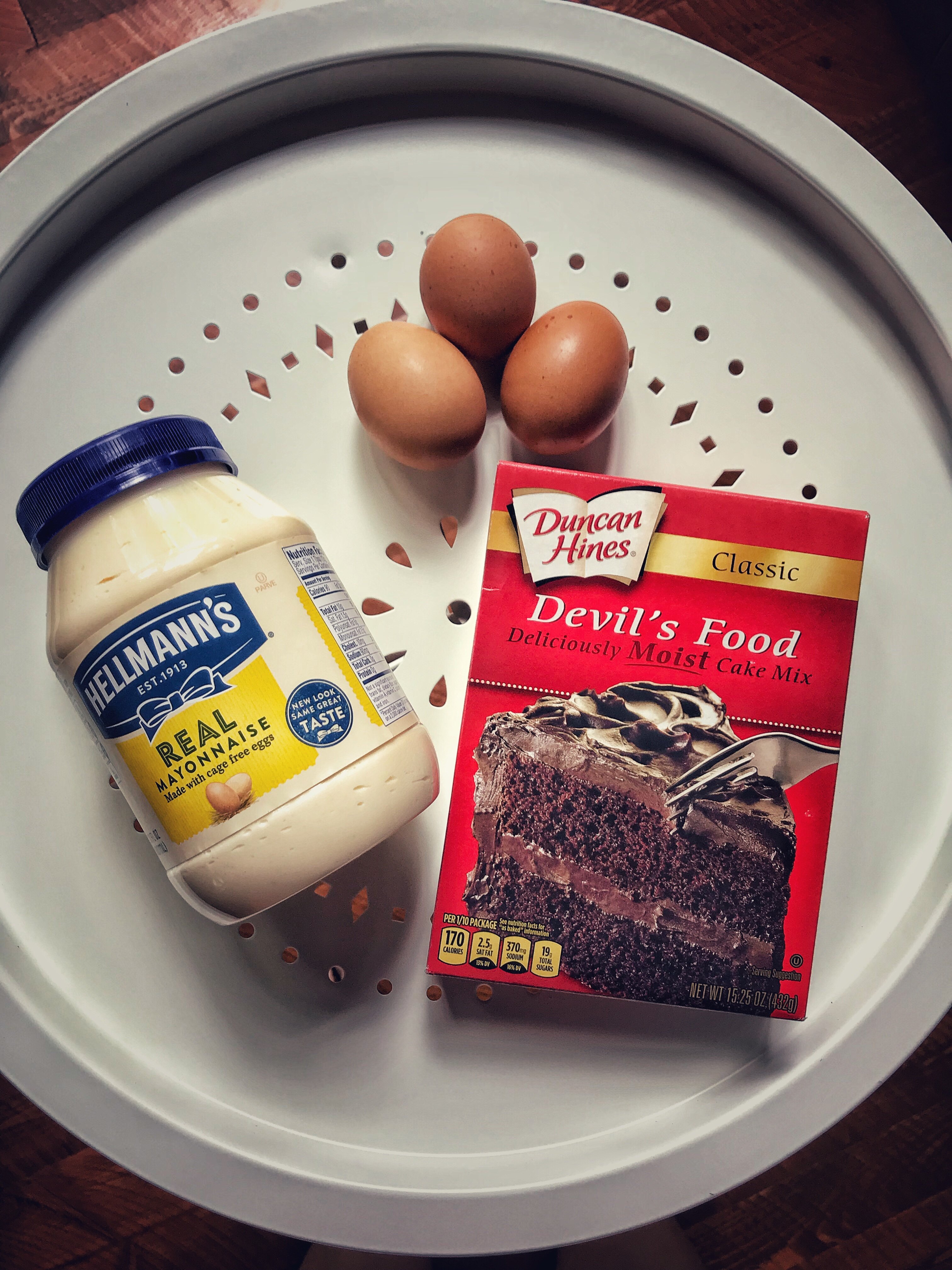 A jar of Hellman's mayo, three eggs, and a box of Duncan Hines Devil's Food cake mix. 
