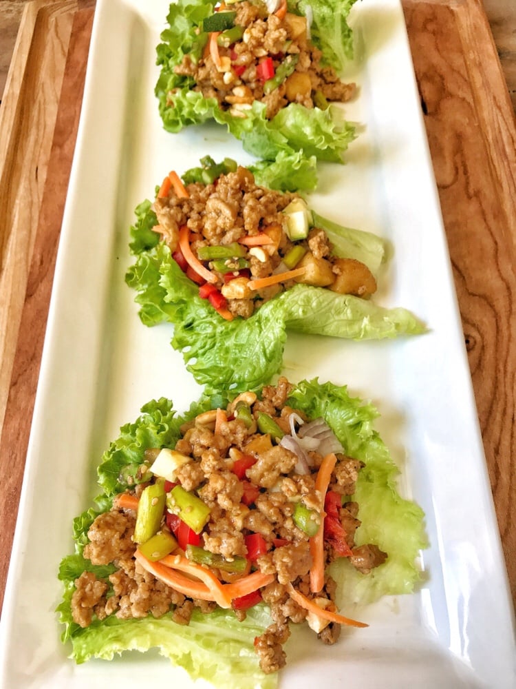 Three lettuce cups with ground meat and vegetables.