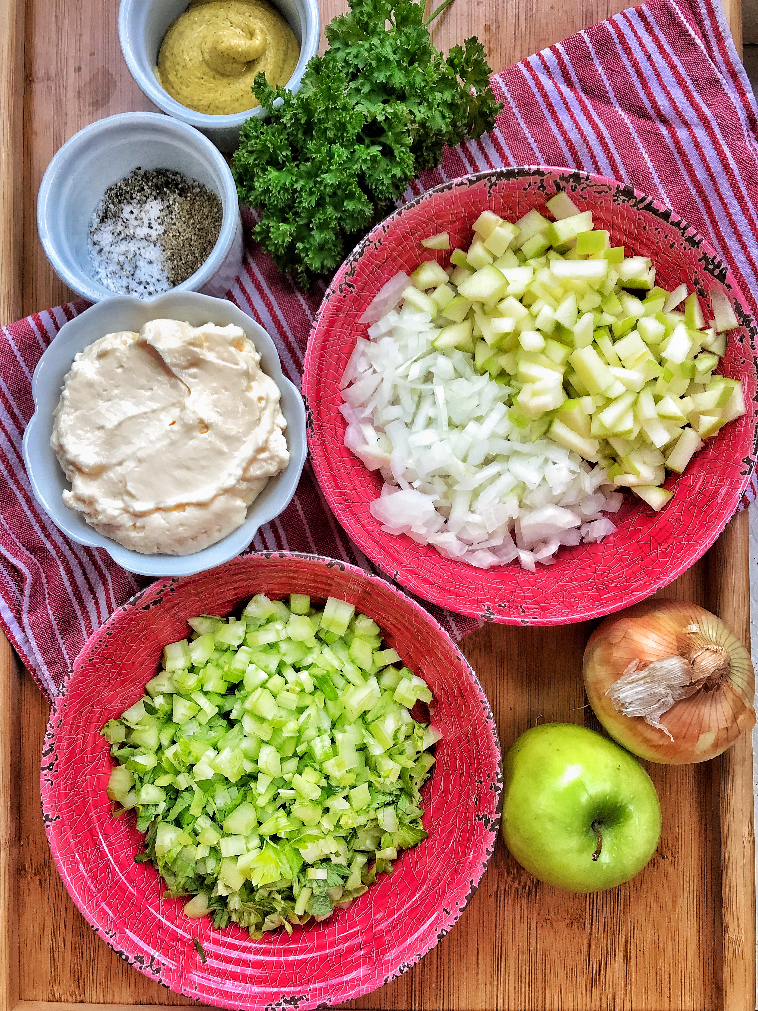 The ingredients for the Spring Potato Salad, including mayo, celery, salt and pepper, onions, green apple, and parsley. 
