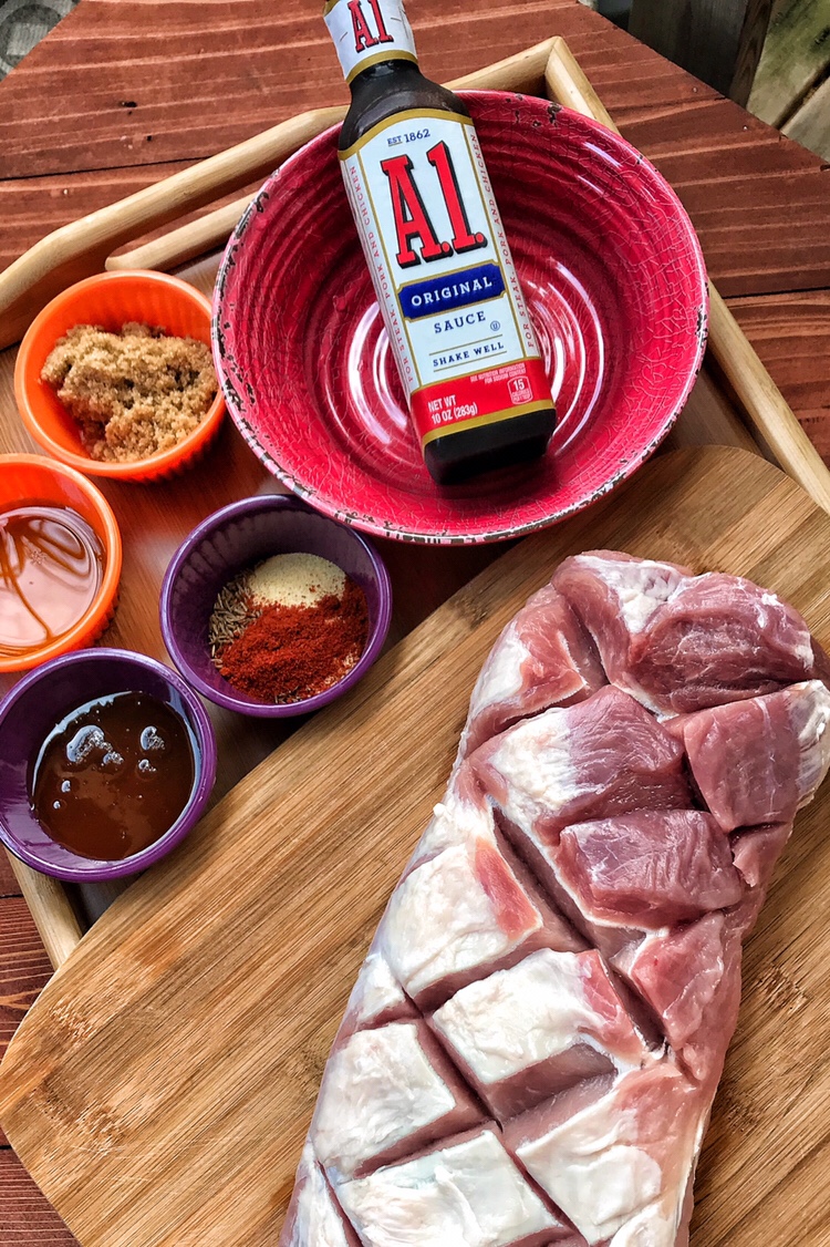 The sauces and spices for the roast pork along with the raw, latticed pork tenderloin.