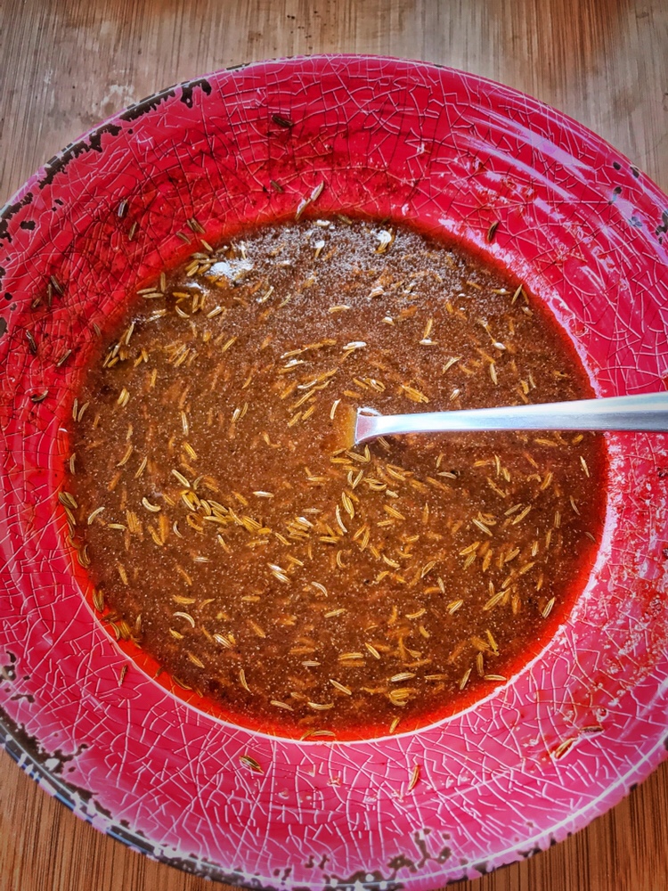 Marinade in a red bowl with a spoon.