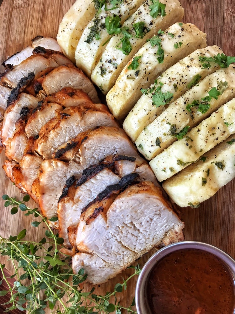 Sliced roast pork next to sliced Czech Dumplings.