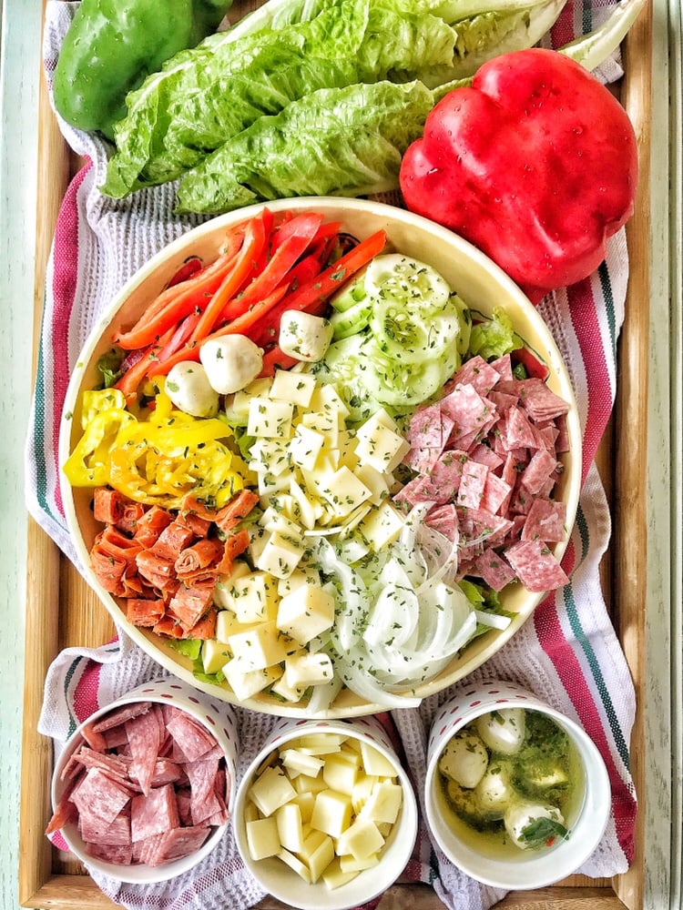 A sub salad with deli meats, peppers, and cheeses.