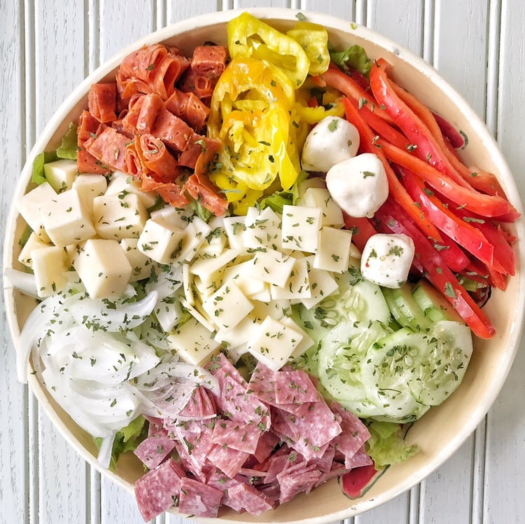 A low carb sub salad with deli meats, peppers, cheeses, and onion.