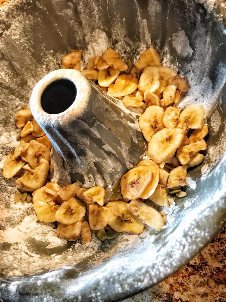 Flour and banana chips in a bundt dish.