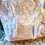 Corn starch and raw chicken in a pastic bag.