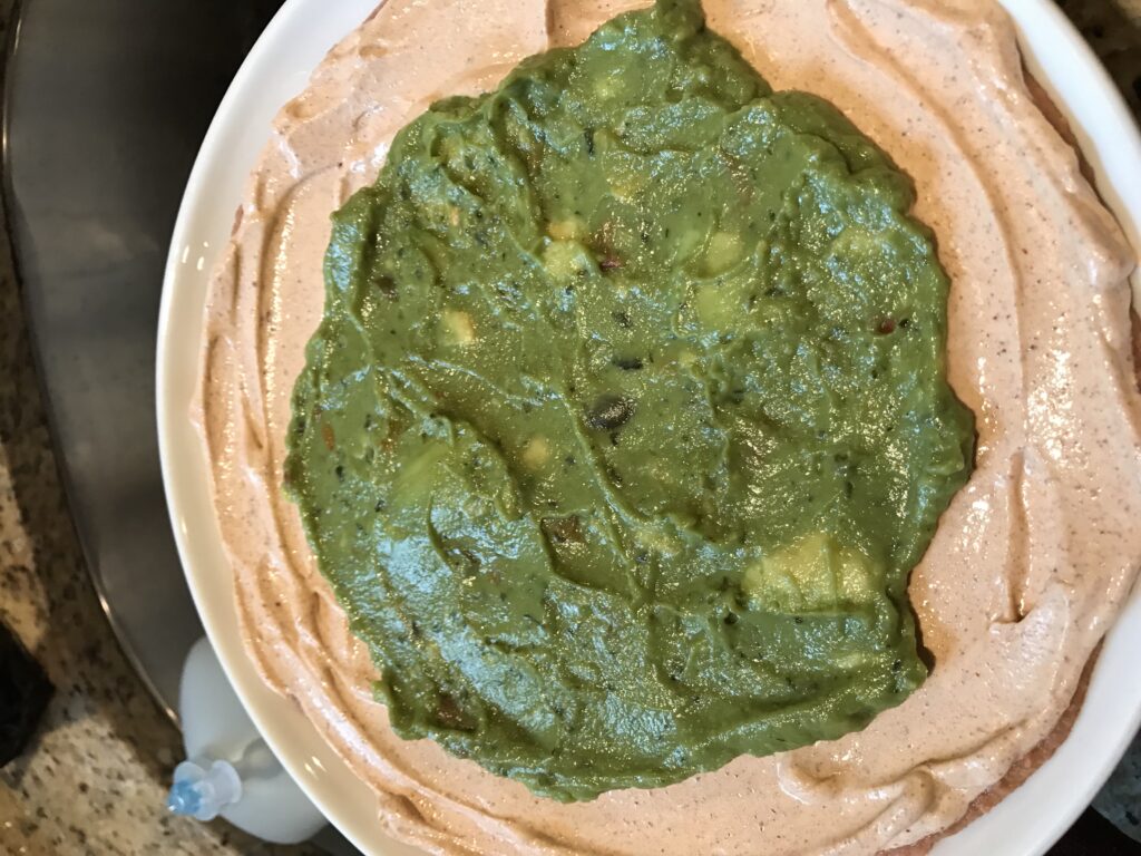 Guacamole on top of the rest of the dip-