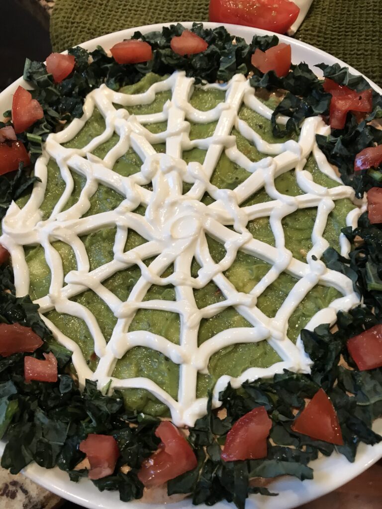 Tomatoes and greens around the sour cream spider web