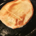 The naan toasting in the skillet