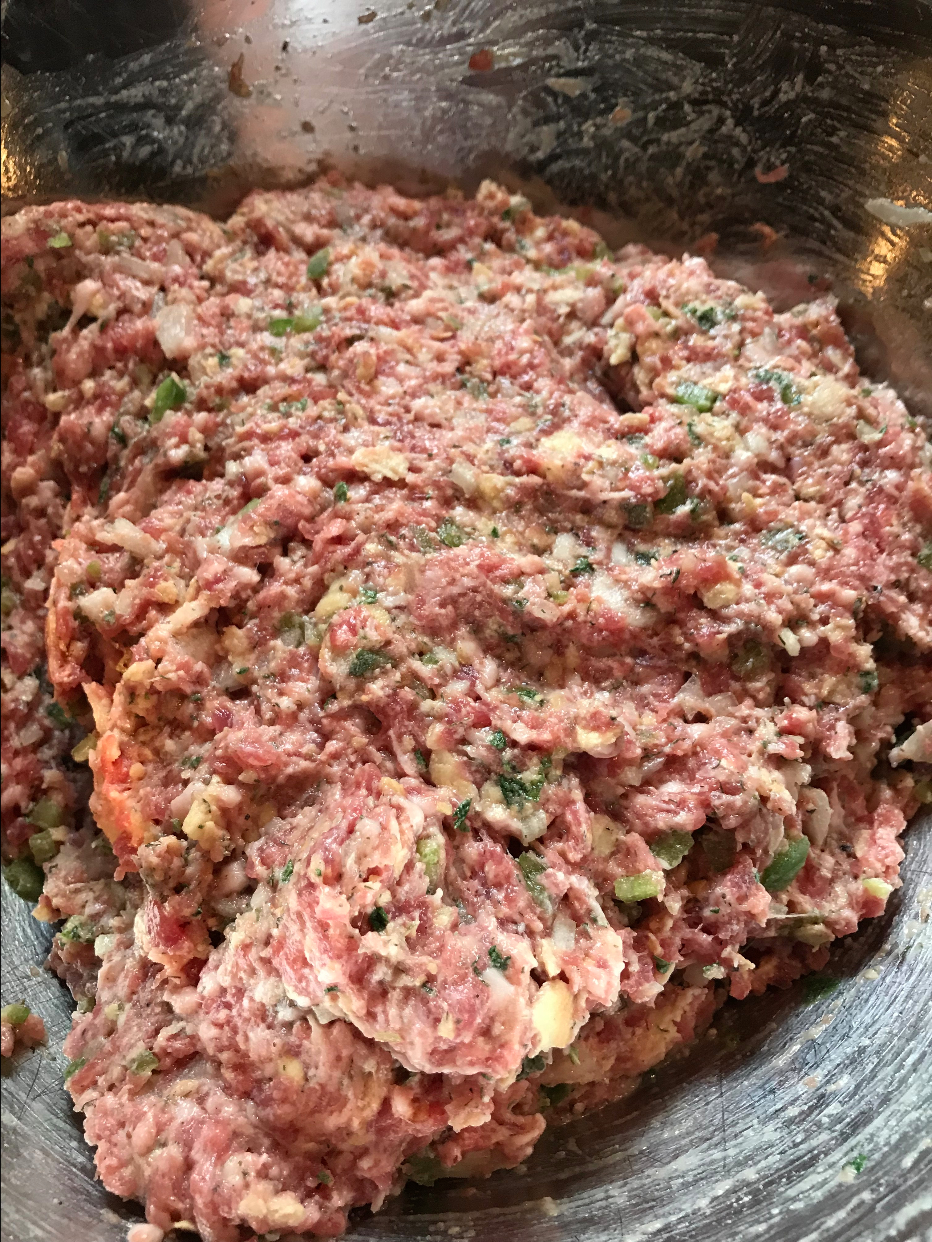 The ground pork mixture in a metal bowl