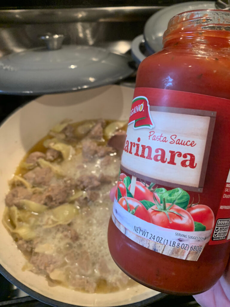 A jar of marinara sauce over the pan