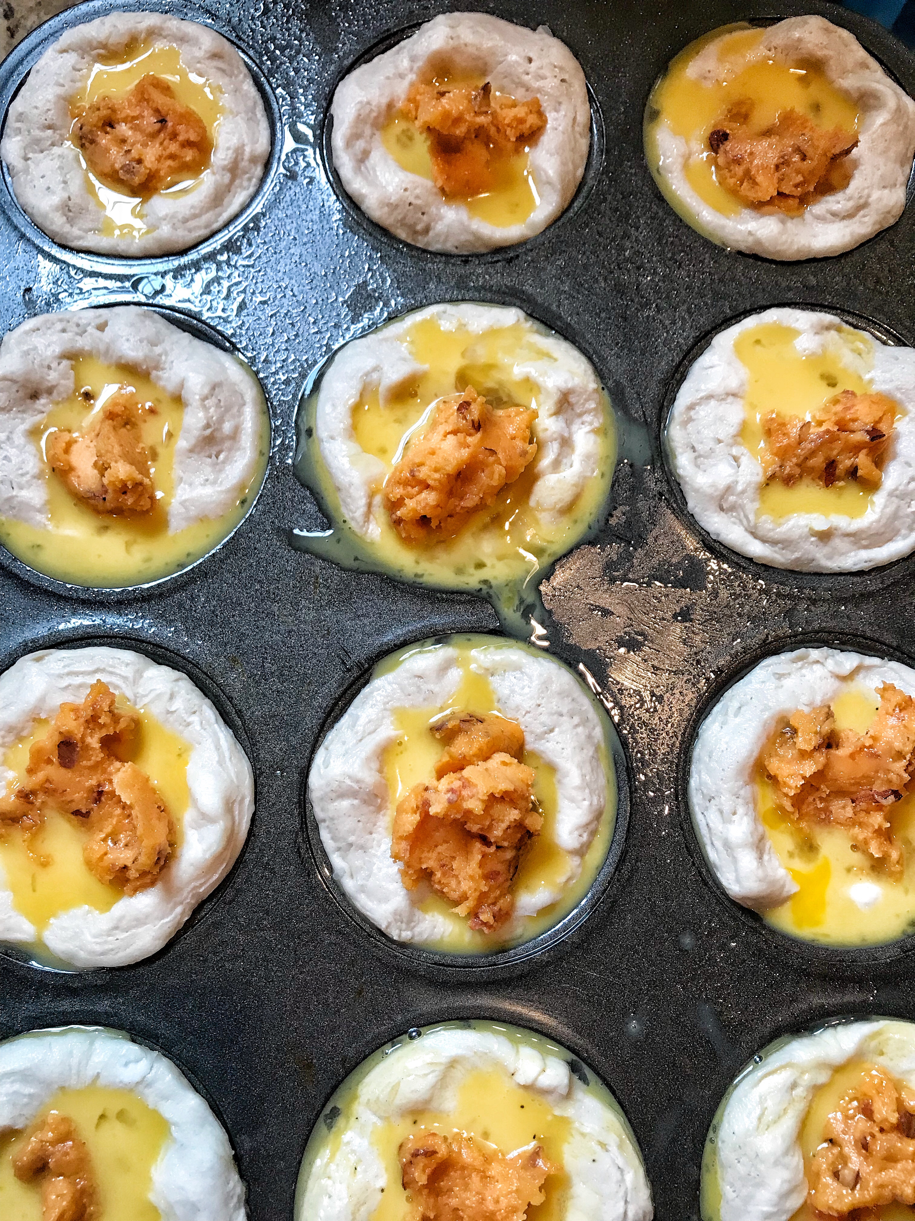 The cheese spread in the biscuit in cups before being cooked