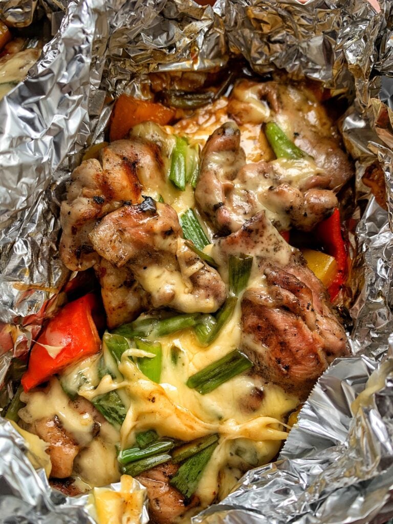 Chicken and peppers in a foil packet with melted cheese