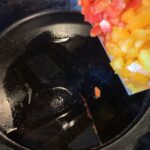 Diced peppers going in a pan