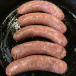 Sausages cooking in a pan