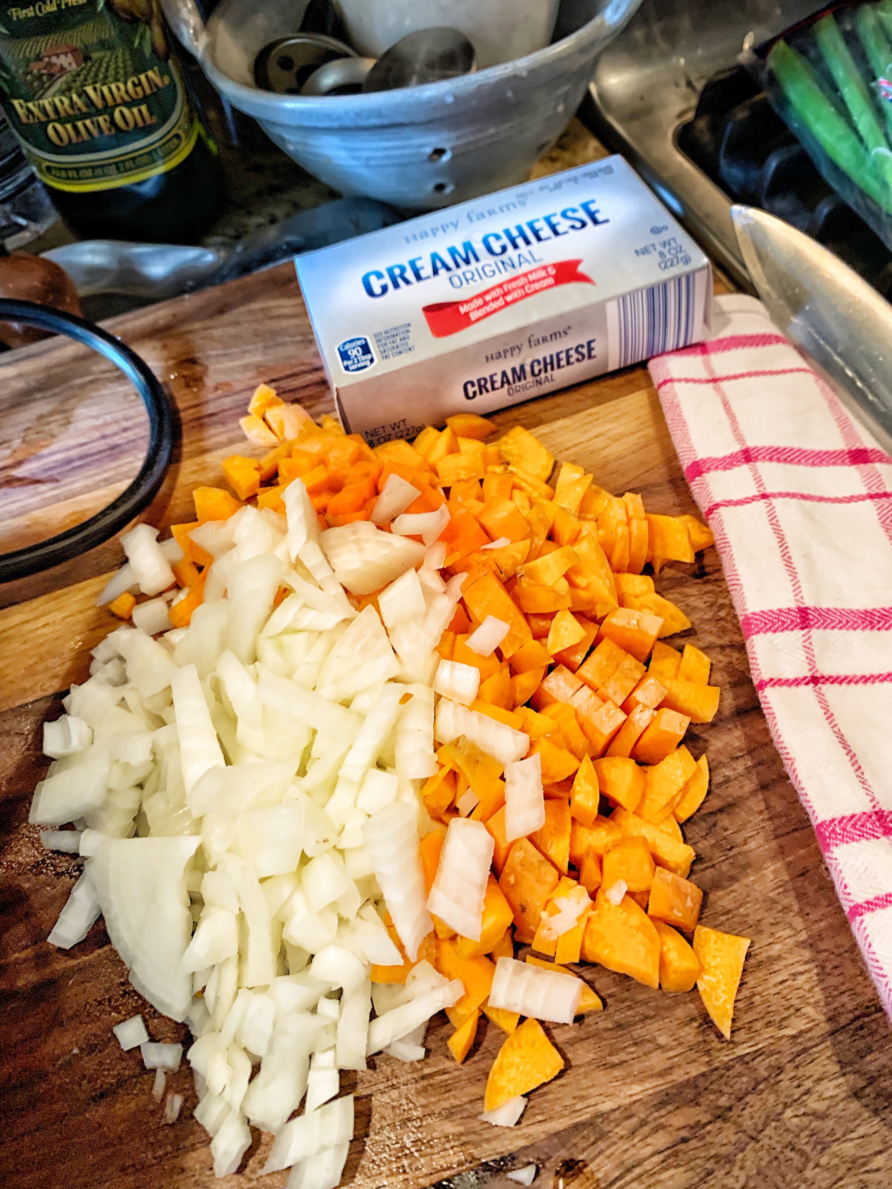 Diced carrot and onion with a brick of cream cheese to the side.