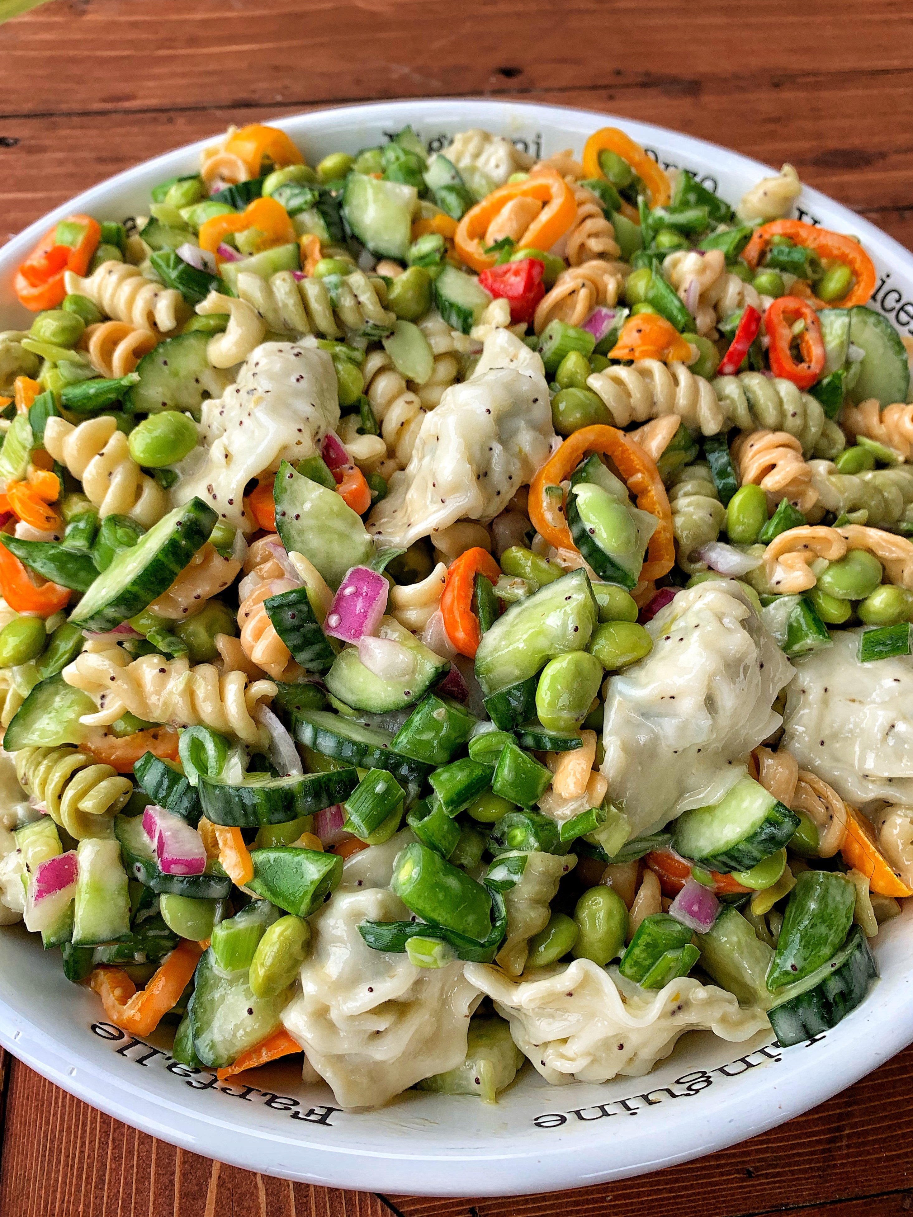 A bowl of veggies and corkscrew pasta.