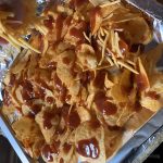 BBQ chips covered in shredded cheese and bacon after being backed