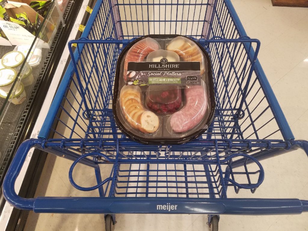 A Hillshire social platter package that includes meats, bread, and cheeses in a shopping cart