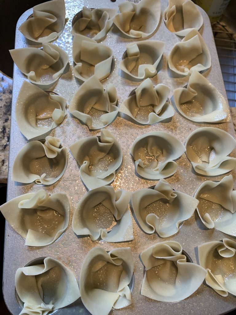 Mini muffin tin with won ton wrappers in the cups