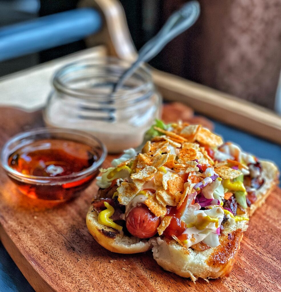 A hot dog with all sorts of toppings, including BBQ potato chips
