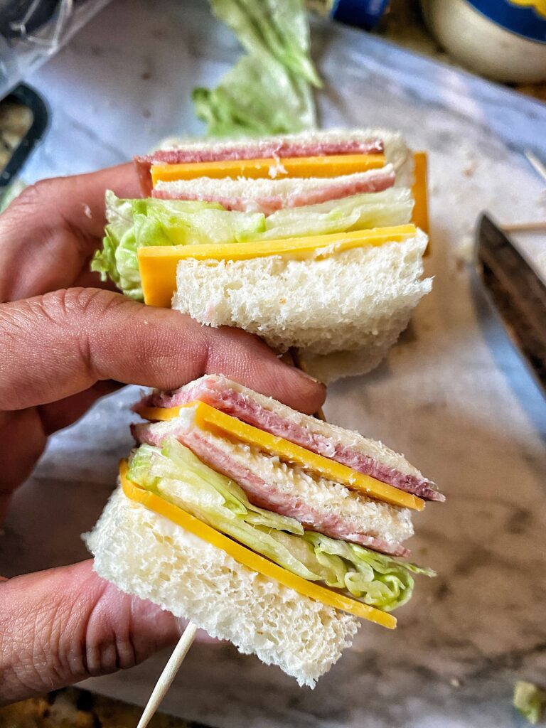 Two salami and cheese beach snacks being held in one hand