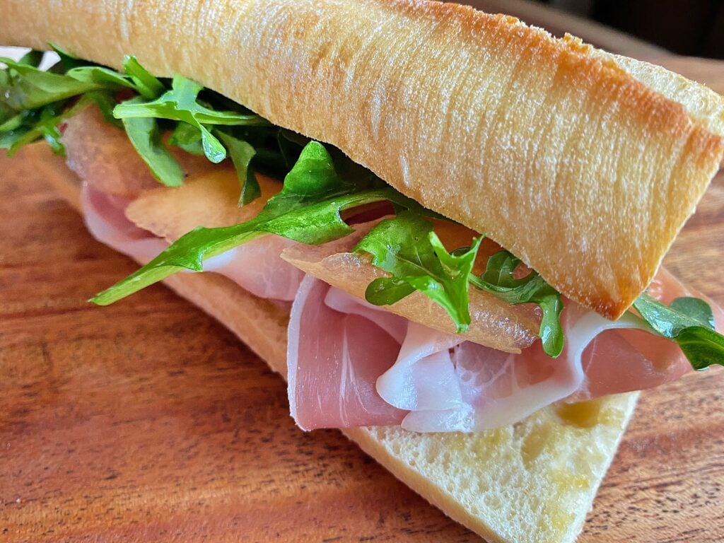 Prosciutto, arugula and cantaloupe on a toasted baguette with butter