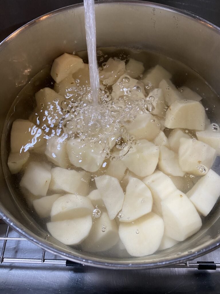 Chunks of potatoes submerged in water