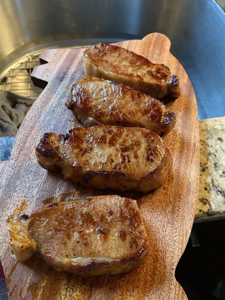 The cooked pork chops on a cutting board
