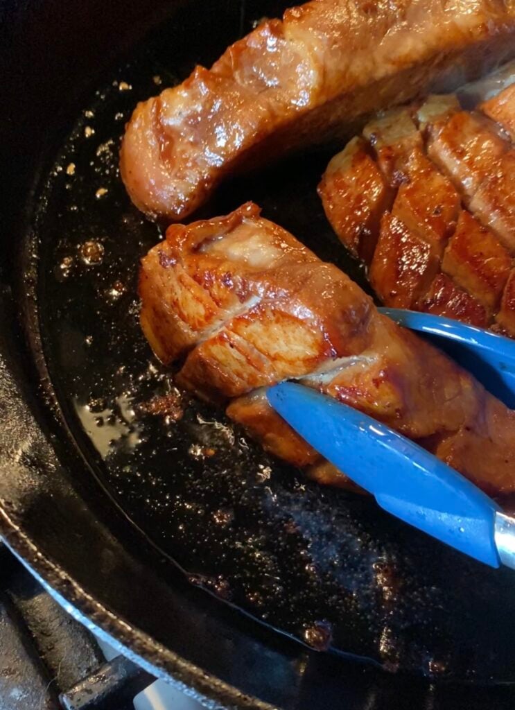 A close up of Asian marinated pork chops on the skillet