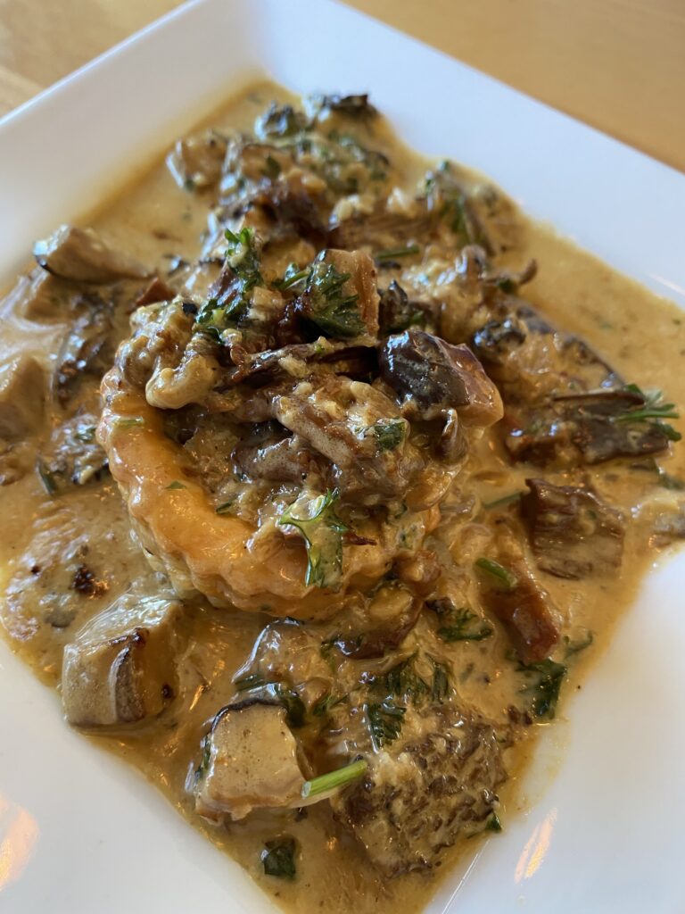 A puff pastry topped with mushrooms in sauce