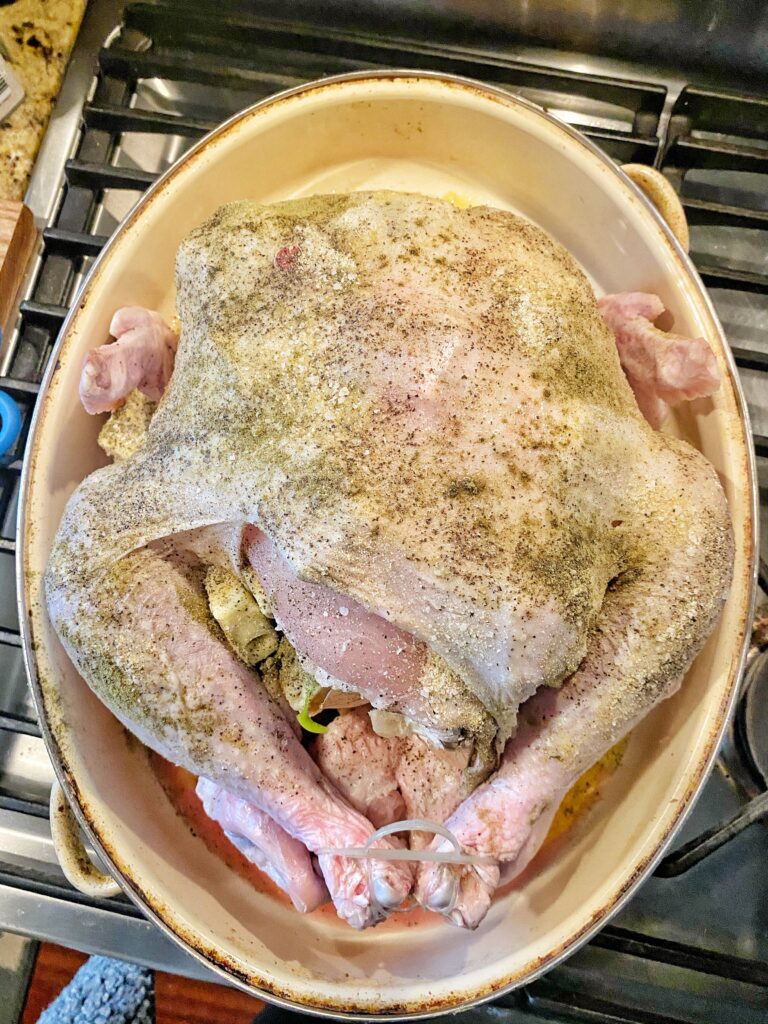 Raw, seasoned turkey with butter stuffed into its crevasses 