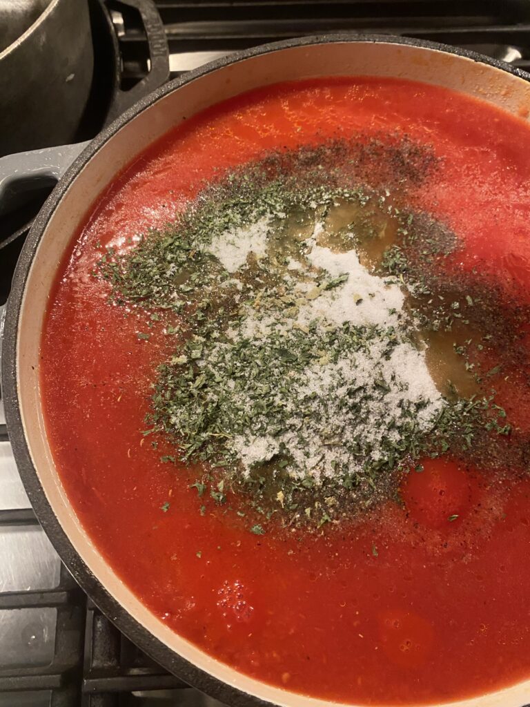 Seasonings on top of a pot of Sunday sauce