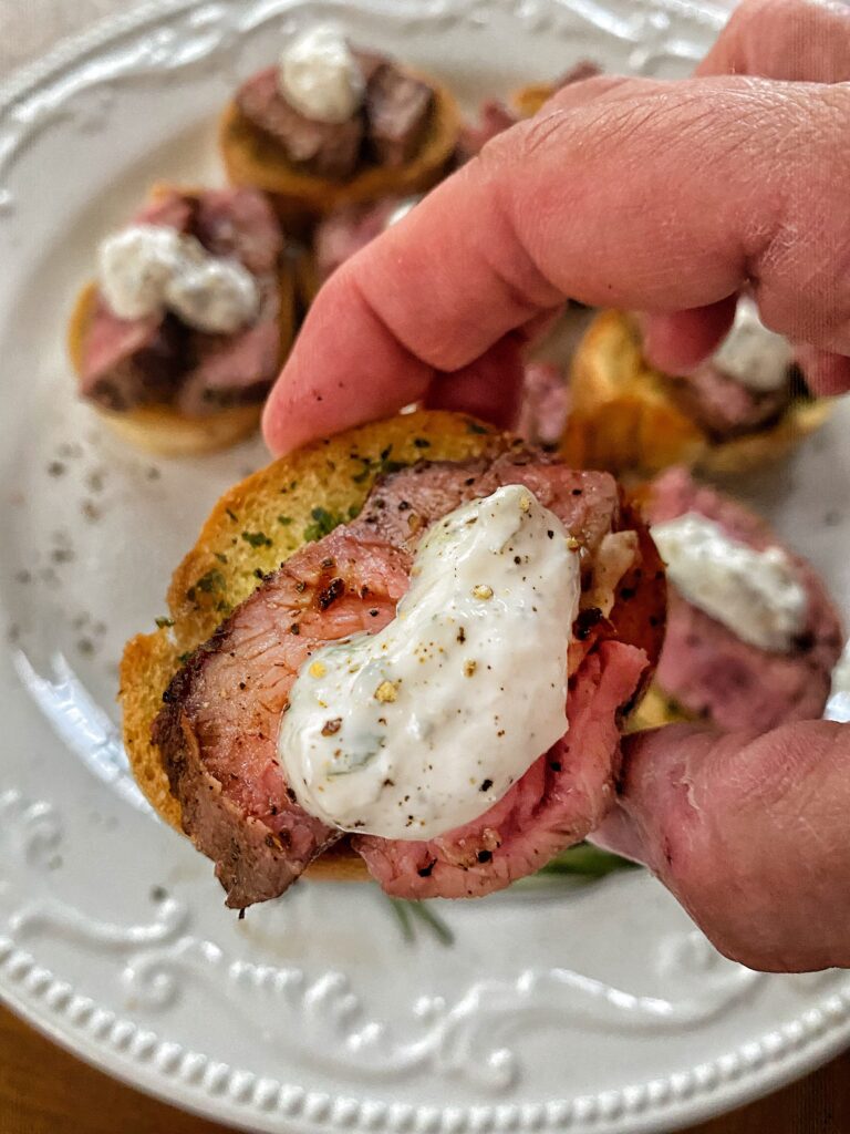 A close up of a garlic steak bite with horseradish cream
