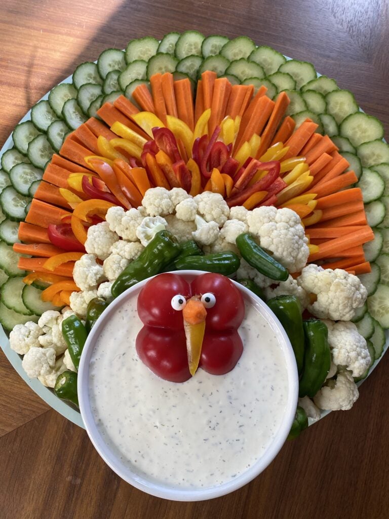 A veggie platter shaped like a turkey with ranch dip