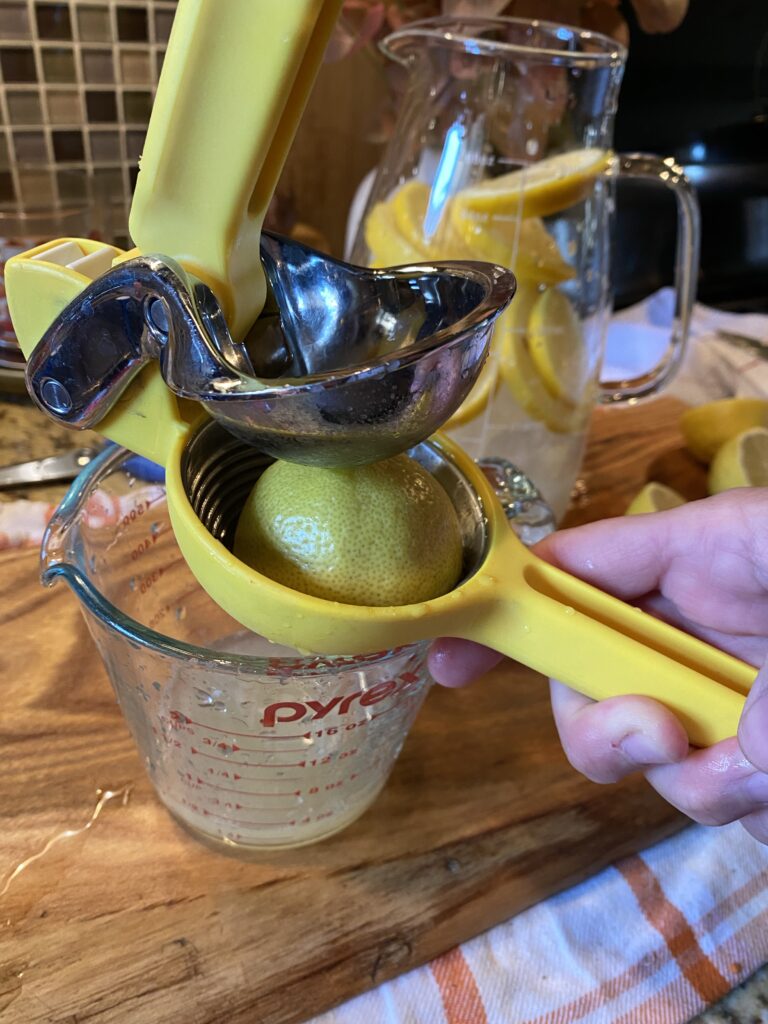 A lemon being squeezed into a measuring Pyrex
